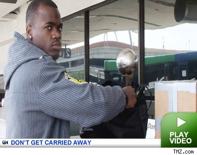 adrian peterson with his espy at the airport on tmz